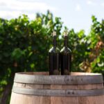 wine bottles on barrel in vineyard